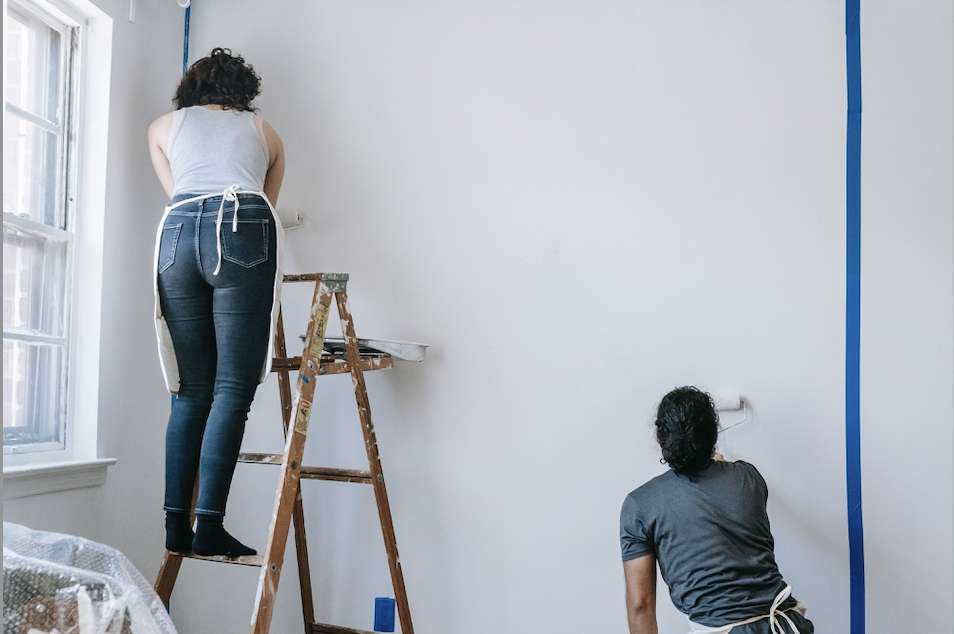 man and woman decorating and painting house
